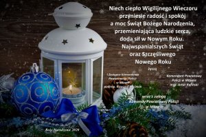 Fotografia: Życzenia z okazji Świąt Bożego Narodzenia - karta świąteczna z białą lampą z palącą się świecą i stroikiem świątecznym w kolorze niebiesko srebrno białym.