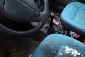 wnętrze samochodu osobowego z rozrzuconymi po podłodze puszkami po piwie
