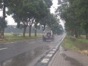 Śliska droga po opadach deszczu, widok przez przednią szybę auta
