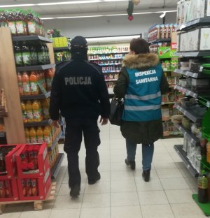 Policjant i przedstawicielka Inspekcji Sanitarnej w sklepie spożywczym