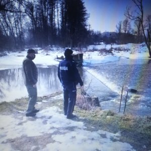 Policjant i Strażnik Rybacki kontrolują brzeg rzeki