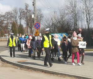 policjantki prowadzą wspólnie z nauczycielkami dzieci chodnikiem