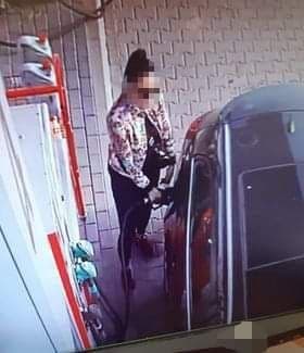 zdjęcie z monitoringu stacji paliw, na którym widać kobietę tankującą samochód osobowy marki opel