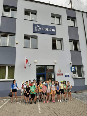 grupa dzieci stojąca przed wejściem do budynku Komendy Powiatowej Policji w Płońsku