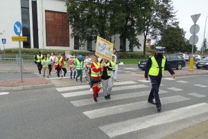 Policyjni profilaktycy razem z uczniami ze Szkoły Podstawowej nr 1 w Płońsku przechodzą po przejściu dla pieszych w czasie akcji Kierowco! Nie polujemy na zebrach