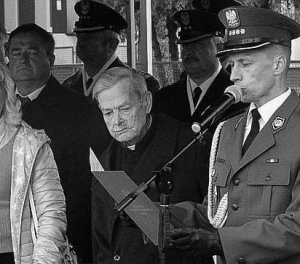 Ks. Kraszewski stoi wraz innymi osobami podczas odsłonięcia tablicy pamiątkowej