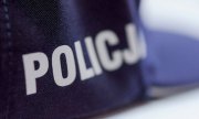 Srebrny napis policja na boku granatowej czapki służbowej z daszkiem
