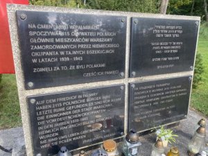 Cztery tablice informujące, że na cmentarzu w Palmirach spoczywa 2115 obywateli polskich. Tablice w języku polskim, niemieckim, rosyjskim i hebrajskim.