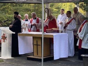 Księża stojący za ołtarzem, a z przodu ksiądz prawosławny