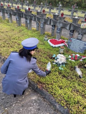 Policjantka stawia znicz na grobie Agnieszki Dowbor Muśnickiej