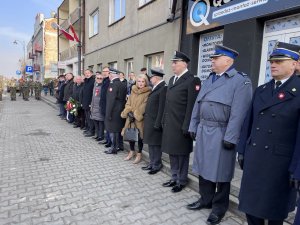 Przedstawiciele służb mundurowych i jednostek samorządowych stojący przy budynku
