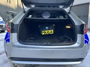 Otwarty bagażnik auta z przytwierdzoną torbą z napisem Policja
