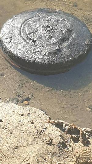 Skorodowana mina przeciwpancerna leżąca w rzece przy brzegu
