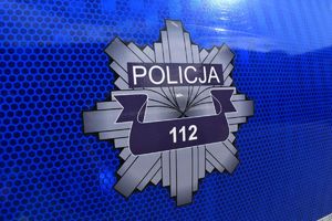 Niebieskie tło a na nim logo Policji jako srebrna ośmioramienna gwiazda. Na środku napis 112, a powyżej napis Policja