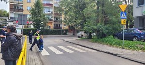 Policjant wchodzący z dzieckiem na przejście dla pieszych