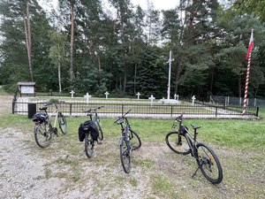 Cztery rowery. W tle cmentarz i groby