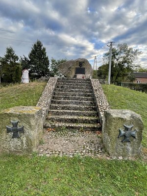 Kamienne schody prowadzące do kamienia z tablicą pamiątkową