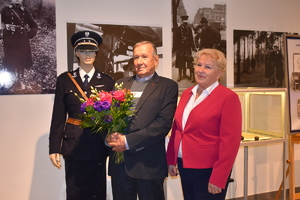 Starszy mężczyzna i kobieta stoją przy manekinie ubranym w mundur policjanta II RP