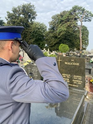 Policjant oddaje honor przed grobem
