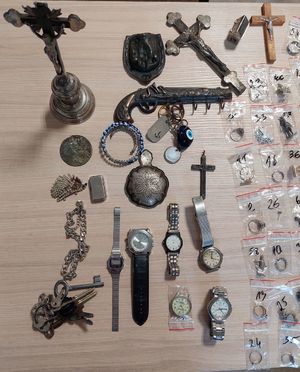Krzyże, zawieszki, medaliki i zegarki leżące na stole