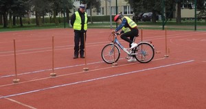 Policjant obserwuje ucznia jadącego na rowerze