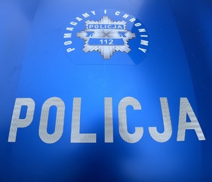 Na niebieskim tle logo policji w kształcie gwiazdy. Na dole napis Policja