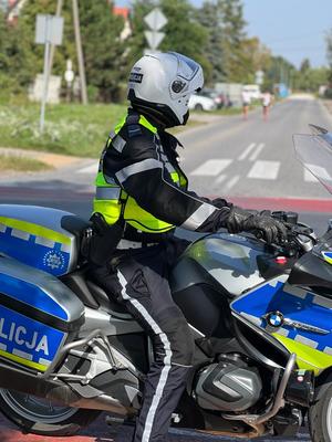 Policjant siedzący na motocyklu patrzy na drogę