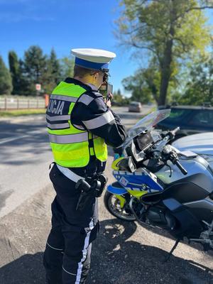 Policjant stojący obok motocykla