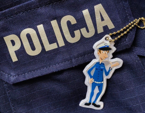 Odblask przedstawiający policjanta na tle munduru z napisem Policja