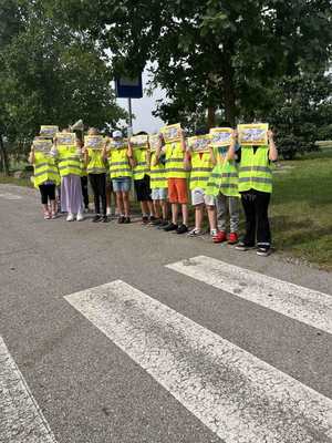 Dzieci z plakatem z napisem Kierowco nie polujemy na zebrach