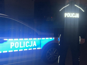 Świecące odblaskowe elementy na radiowozie i bluzie policjanta