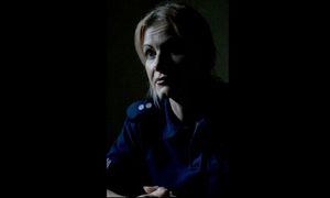 Policjantka siedząca w półmroku