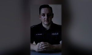 Policjant siedzący w półmroku