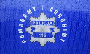 Niebieskie tło z logo policji w kształcie ośmioramiennej krawędziowej gwiazdy. W środku napis 112 pomagamy i chronimy