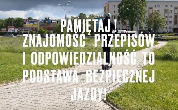 Widok na osobę jadącą hulajnogą w kasku. Napis Pamiętaj! Znajomość przepisów i odpowiedzialność to podstawa bezpiecznej jazdy
