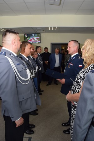 Policjant i kobieta stoją naprzeciwko rzędu policjantów