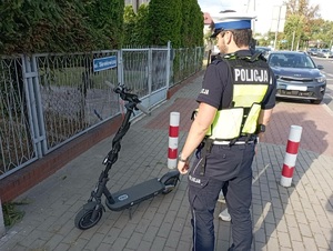 Policjant stoi przy hulajnodze