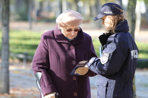 Policjantka stoi obok starszej kobiety