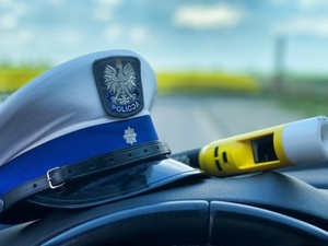 Czapka i urządzenie do badania stanu trzeźwości leżące na podszybiu auta