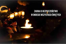 Palący się znicz w nocy i napis Zadbaj o bezpieczeństwo w okresie wszystkich świętych