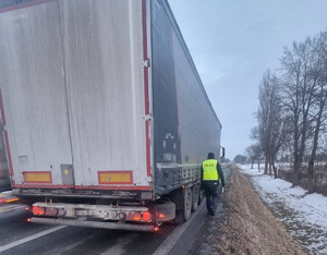 Policjant idący obok ciężarówki