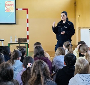 Policjantka jest zwrócona w stronę uczniów i gestykuluje