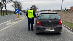 Policjant stoi przy samochodzie