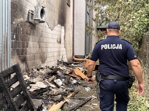 Policjant idzie obok budynku