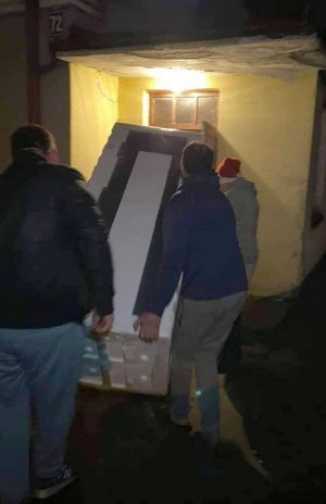 Mężczyźni wnoszący lodówkę do domu