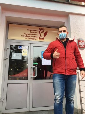 Policjant stojący przez wejściem do Regionalnego Centrum Krwiodawstwa i Krwiolecznictwa w Warszawie