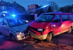 Na zdjęciu widzimy zderzone ze sobą dwa samochody. W tle niebieskie światła błyskowe.