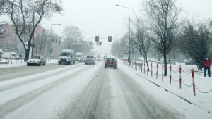 Samochody jadące po zaśnieżonej ulicy