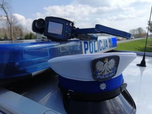RMP leży na sygnałach świetlnych radiowozu policyjnego. Obok czapka policjanta WRD