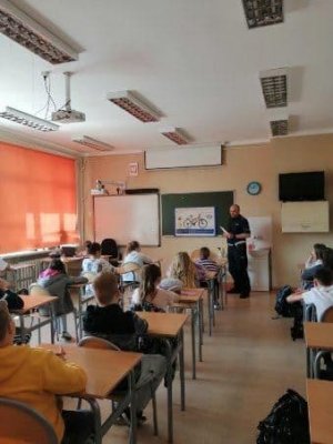 Lekcja bezpieczeństwa w ruchu dla uczniów szkoły, która prowadzi policjant
